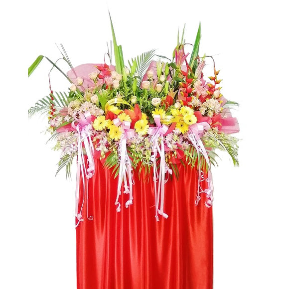 Pink lilies, yellow gerbera, peach roses and heliconia grand opening congratulatory flowers