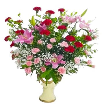 Red carnations, pink carnations and pink lilies table flower arrangement