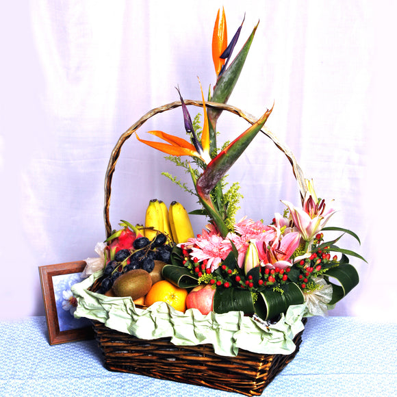 Fruit basket arranged with exotic bird's of paradise, pink gerberas, pink lilies and hypericums by Katong Flower Shop for Singapore Delivery Options_Free Delivery